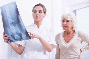 γιατρός που δείχνει ασθενή ακτινογραφία της σπονδυλικής στήλης